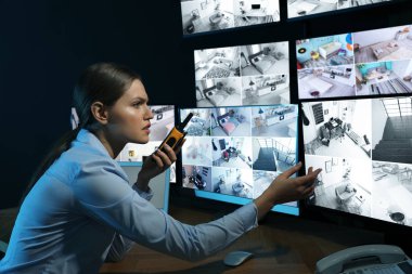 Mobil vericili güvenlik görevlisi modern CCTV 'yi izliyor. 