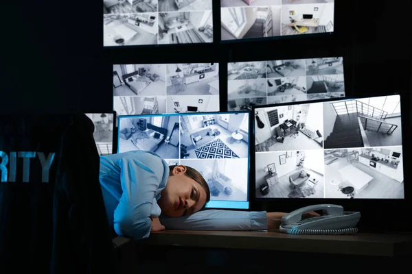 Tired security guard sleeping in office at night — Stock Photo, Image