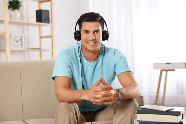 Man listening to audiobook on sofa at home — 스톡 사진