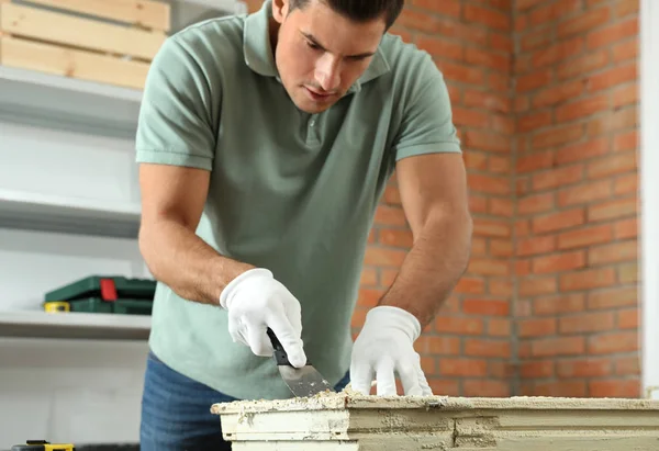 Man repareert oude beschadigde raam aan tafel binnen — Stockfoto