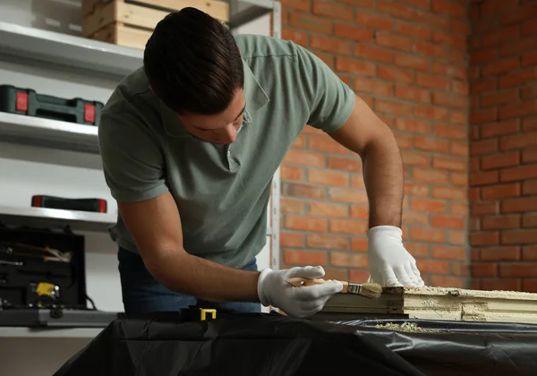 Man reparerar gamla skadade fönster vid bordet inomhus — Stockfoto