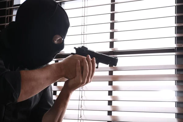 Hombre Con Máscara Apuntando Través Persianas Ventana Interior —  Fotos de Stock