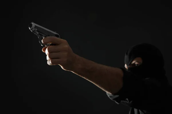 Asesino profesional sobre fondo negro, enfoque en arma —  Fotos de Stock