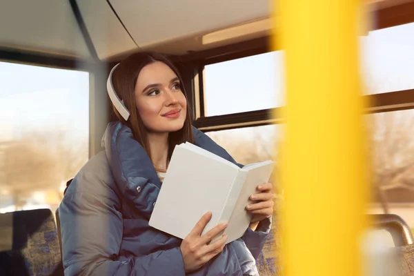 Woman listening to audiobook in trolley bus — Stock Photo, Image