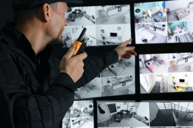 Mobil vericili güvenlik görevlisi modern CCTV 'yi izliyor. 