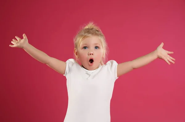 Porträt eines emotionalen kleinen Mädchens auf rosa Hintergrund — Stockfoto