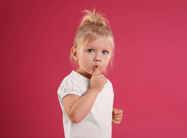 Portret van emotioneel klein meisje op roze achtergrond — Stockfoto