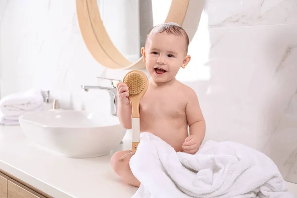 Bebê bonito sentado na bancada no banheiro — Fotografia de Stock