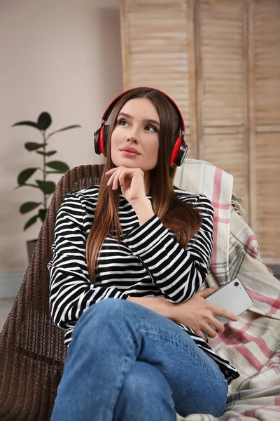 Žena poslouchající audioknihu doma v křesle — Stock fotografie