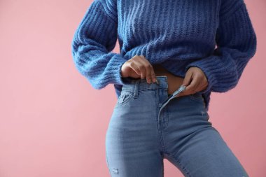 Pembe arka planda düğmelerini açan kadın, yakın plan.