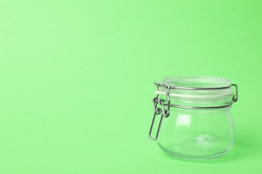 Açık yeşil arkaplanda boş cam kavanoz, metin için boşluk