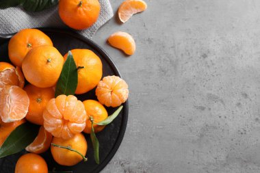 Açık gri masada taze, olgun mandalinalar, düz yatıyordu. Metin için boşluk