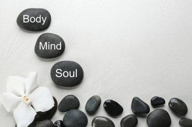 Sözcükler içeren taşlar Zihin, Vücut, Ruhun açık arkaplanda olduğu, üst görünüm ve metin için boşluk. Zen yaşam tarzı