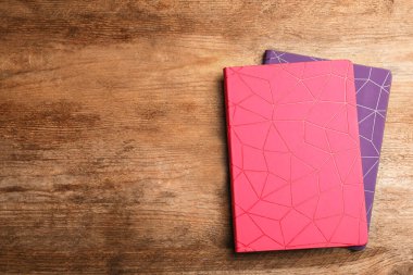 Ahşap masa üzerinde şık defterler, üst manzara. Metin için boşluk