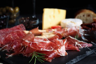 Gri masada servis edilen lezzetli prosciutto, yakın plan.