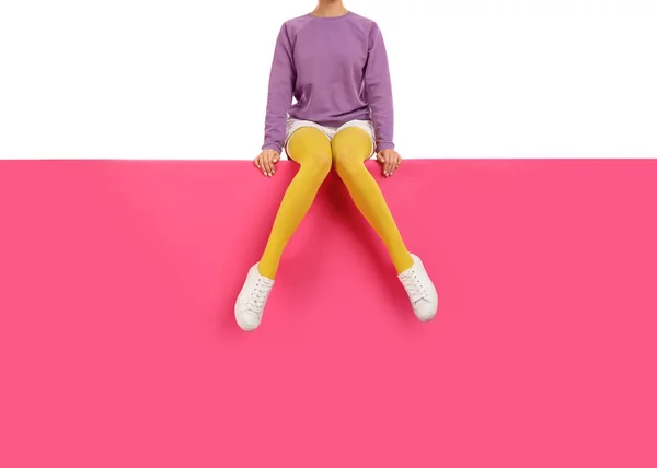 Mujer con medias amarillas y zapatos elegantes sentado en el color b — Foto de Stock