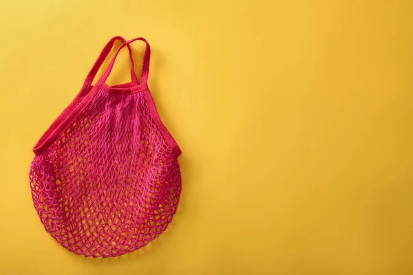 Leere rosa Netztasche auf gelbem Hintergrund, Draufsicht. Raum für Neues — Stockfoto