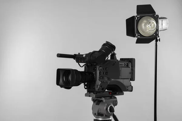 Professionelle Videokamera Und Beleuchtungsgeräte Auf Weißem Hintergrund — Stockfoto