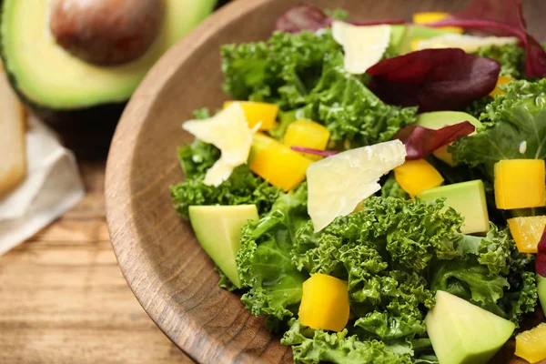 Delicious kale salad in wooden bowl, closeup