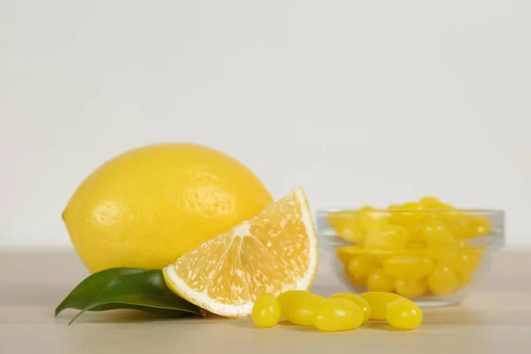 Verse citroen en smakelijke kleine druppels op houten tafel — Stockfoto