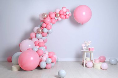 Işık duvarının yanında balonlar ve şekerlerle güzel bir kompozisyon.