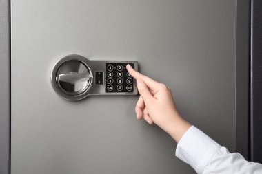 Çelik kasayı elektronik kilitle açan kadın, yakın plan.