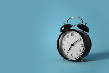 Açık mavi zemin üzerindeki alarm saati, metin için boşluk. Sabah oldu.