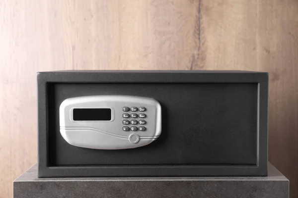 Black steel safe with electronic lock on grey table