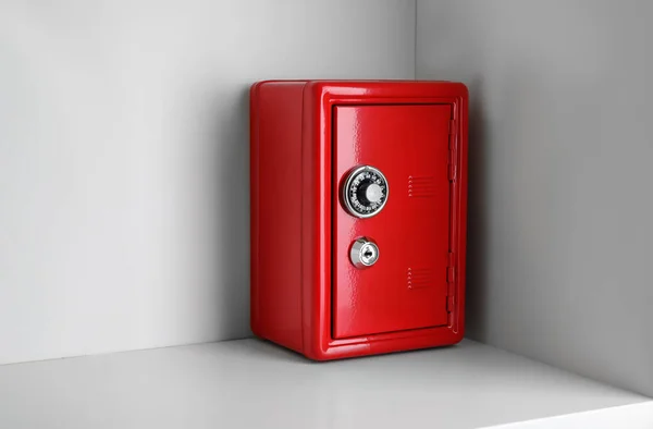 Red steel safe with mechanical combination lock on shelf