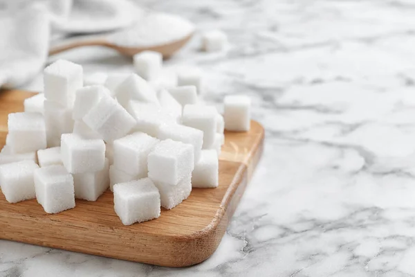 Изысканные кубики сахара на белом мраморном столе. Пространство для текста — стоковое фото