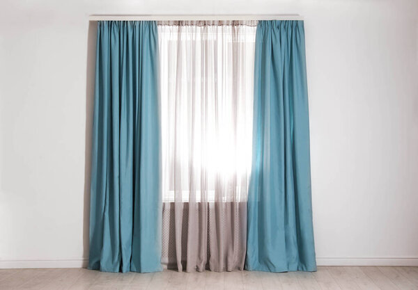 Window with elegant curtains in empty room