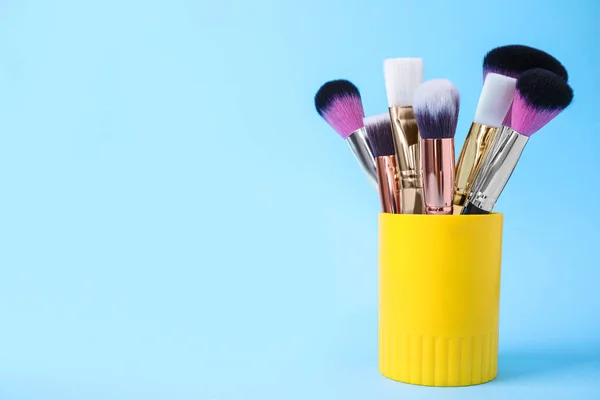 Conjunto de escovas de maquiagem profissional em suporte em backg azul claro — Fotografia de Stock