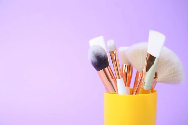 Conjunto de escovas de maquiagem profissional em suporte sobre fundo lilás — Fotografia de Stock
