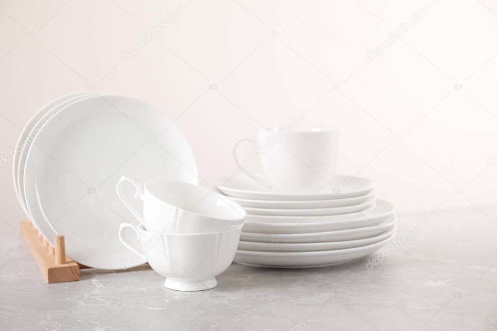 Set of clean tableware on light grey marble table