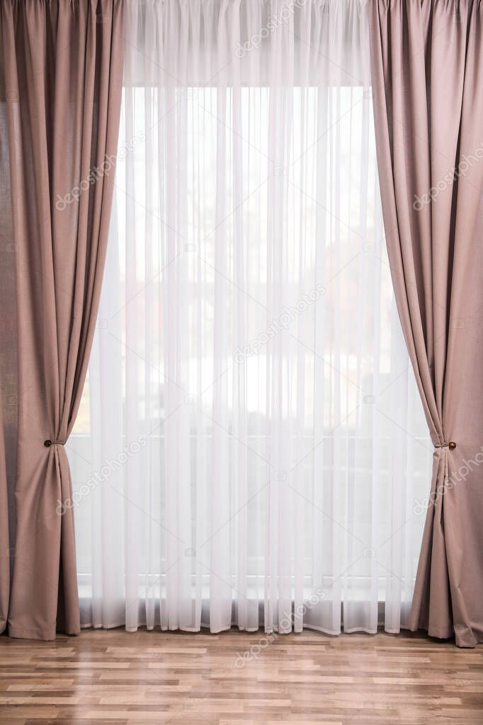 Window with elegant curtains in empty room