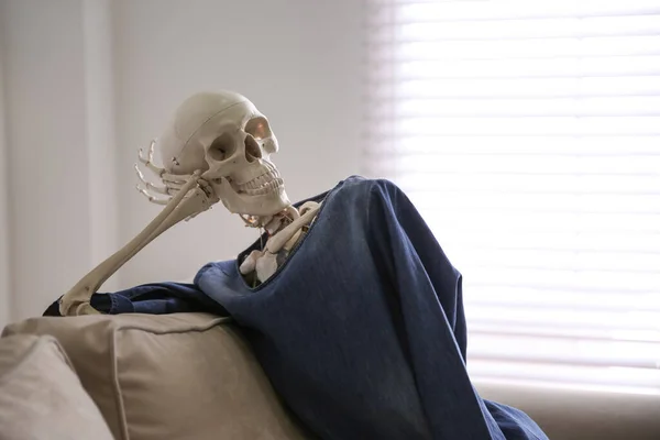 depositphotos_334705848-stock-photo-human-skeleton-on-sofa-in.jpg