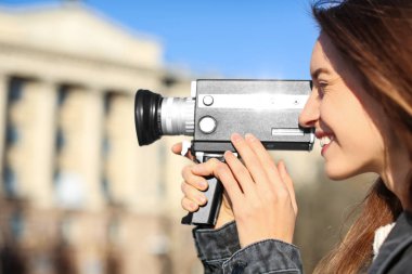 Şehir caddesinde eski model video kameralı güzel bir kadın.
