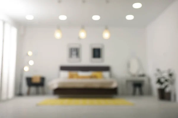 Vista borrosa del elegante interior de la habitación con cama cómoda — Foto de Stock