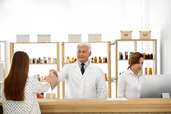 Farmacéutico dando medicamentos al cliente en la farmacia —  Fotos de Stock