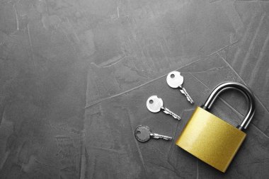 Çelik asma kilit, anahtarlar ve gri arka plandaki yazı için boşluk, düz konum. Güvenlik kavramı