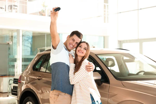 Coppia Felice Con Chiave Della Macchina Nella Moderna Concessionaria Auto — Foto Stock