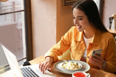 Kafede dizüstü bilgisayarla çalışan genç blogcu