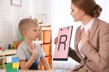 Konuşma terapisti ofiste küçük bir çocukla çalışıyor.