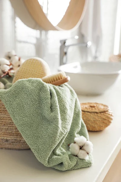 Panier en osier avec serviette propre, brosse de massage et fleurs de coton — Photo