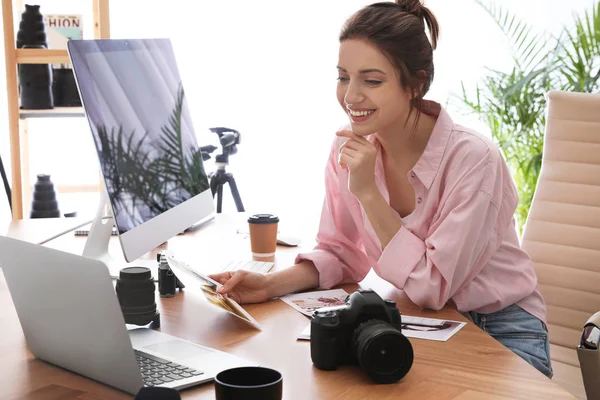 Professional photographer working at table in office