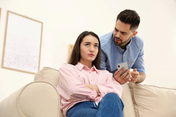 Casal jovem discutindo sobre smartphone em casa. Problemas em relat — Fotografia de Stock