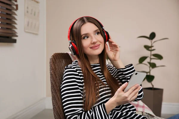 Mujer escuchando audiolibro en silla en casa — Foto de Stock