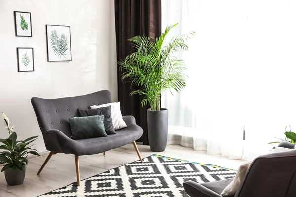 Удобный диван у окна с элегантными шторами в комнате — стоковое фото