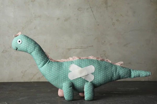 灰色石桌上粘贴石膏的玩具恐龙 — 图库照片