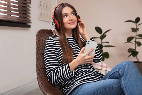 Woman listening to audiobook in chair at home — 스톡 사진